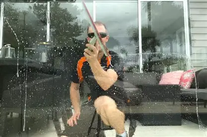 Professional window cleaner working on a residential home